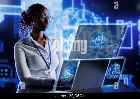 African american scientist using cognitive computing simulating human brain thought processes in computerized model. AI machine visualization showing deep learning algorithms using pattern recognition Stock Photo