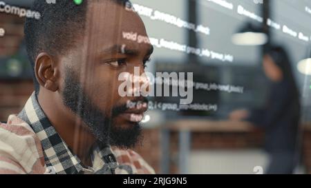 Developer helped by augmented reality to visualize script, writing code on computer screen while in workspace using Java programming languages. African american licensed professional mending errors Stock Photo