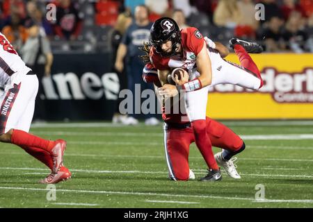Ottawa Redblacks quarterback Dustin Crum, right, leaps away from