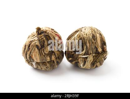 Floral green Chinese tea, tied tea balls with dried flowers, blooming fragrant tea isolated on white background. Stock Photo