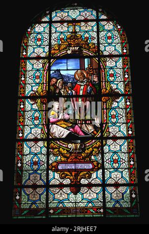 Stained glass window depicting Christian themes in Saint Cornely church in Carnac in Brittany France Stock Photo