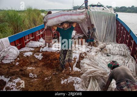 Wood husks are unloaded from the boat. This photo was taken on September 14, 2022, from Ruhitpur, Bangladesh Stock Photo