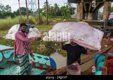 Wood husks are unloaded from the boat. This photo was taken on September 14, 2022, from Ruhitpur, Bangladesh Stock Photo