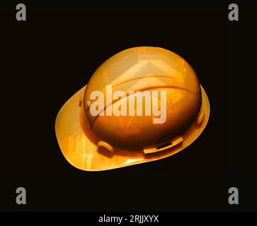 Safety helmet on dark background, Yellow helmet for labourers, Workers and Earth movers, Construction image double exposure on helmet body, Constructi Stock Photo