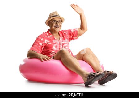 Mature man sitting on a big inflatable rubber ring and waving isolated on white background Stock Photo