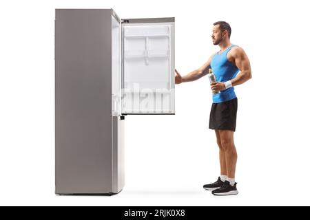 Fit man in sportswear opening an empty fridge isolated on white background Stock Photo
