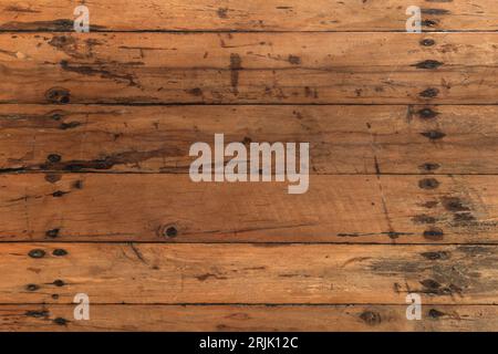 Old wooden flooring made of rough uncolored planks with nails. Top view, background photo texture of lacquered floor boards Stock Photo