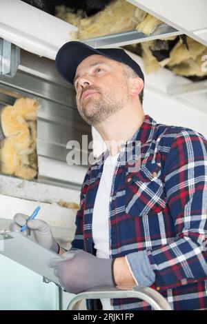 man inspecting insulation in a building Stock Photo