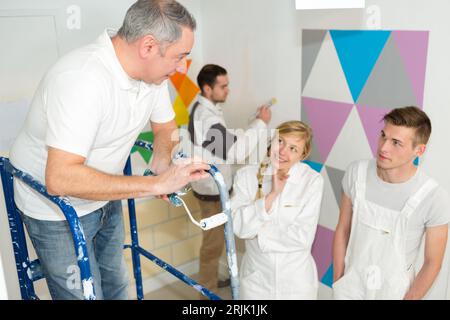 painter with apprentices and client Stock Photo