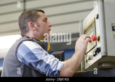 man operating machine in factory Stock Photo
