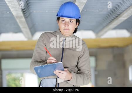 female contractor writing on clipboard Stock Photo
