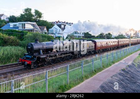 Chalkwell, Southend on Sea, Essex, UK. 23rd Aug, 2023. A steam train has left Southend on Sea early in the morning heading to Bristol Temple Meads, passing alongside the flat calm Thames Estuary at Chalkwell. The Railway Touring Company organised special train is being hauled by ex-British Rail steam locomotive LMS Jubilee Class 5690 Leander. Leander is one of a number of steam locomotives cleared to run on mainlines for special trips and was built in 1936. It was renumbered 45690 by British Railways in 1948 following nationalisation Stock Photo