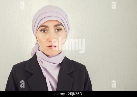 Muslim woman with excitement stands at white studio wall Stock Photo