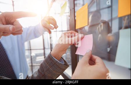 hand glues empty sticker on office window. Stock Photo