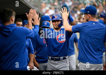 Chicago Cubs' Seiya Suzuki, left, is congratulated by first base coach Mike  Napoli after hitting a single against the San Francisco Giants during the  eighth inning of a baseball game in San