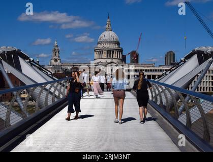 London, UK. 21st August 2023. People walk along Millennium Bridge as sunshine and warm weather return to London after days of wet and cold weather. Stock Photo