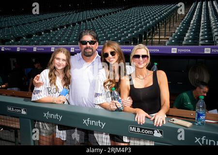 Seven-year-old Tierney Faith Helton, daughter of Colorado Rockies first  baseman Todd Helton, smiles after selecting gum from dispensers in the  dugout as she watches her father take part in a baseball workout