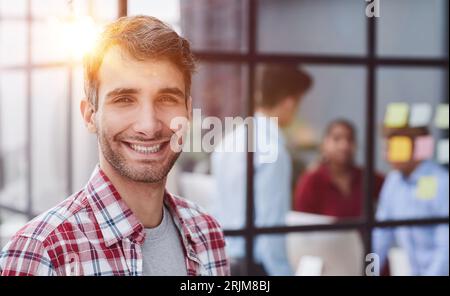 Portrait of casual smiling Caucasian male worker laughing looking at camera Stock Photo