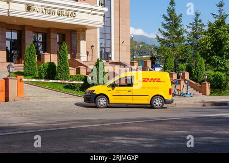 Almaty, Kazakhstan - August 17, 2023: A DHL vehicle is parked in a parking lot near a barrier. Transporting goods Stock Photo