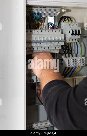 An electric technician operating a control panel in a power station. Stock Photo