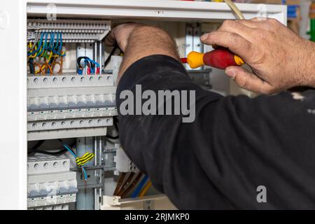 An electric technician operating a control panel in a power station. Stock Photo
