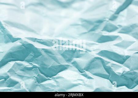 Blank coloured grunge crumpled paper background with folds. A selective focus of paper. Stock Photo