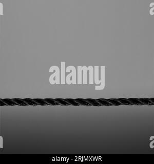 Black rope close-up on black background. Selective focus. Stock Photo
