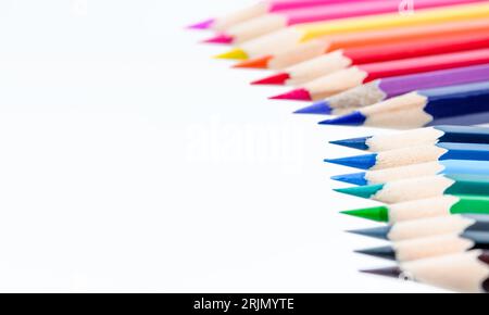 A row of wooden colored pencils isolated on white background. Stock Photo