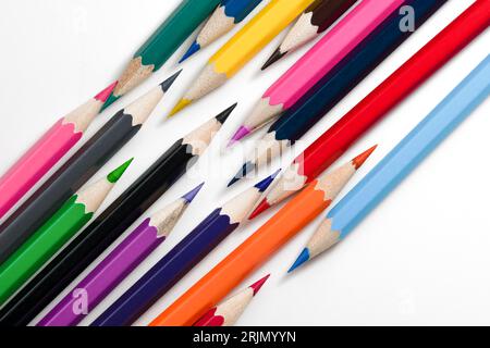 Pencils background. Colored pencils are scattered on white background. Set of bright pencils for drawing. Mock up pencil or crayons. Stock Photo