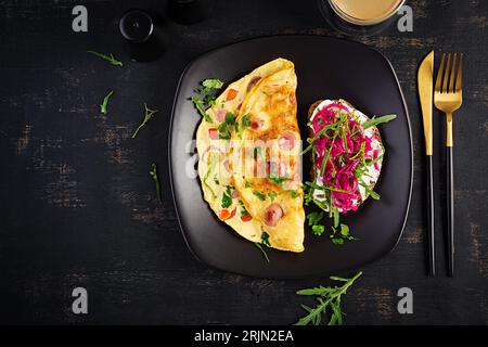 Breakfast. Omelette with sausage, sweet peppers and sandwich with marinated red onions. Frittata - italian omelet. Top view Stock Photo
