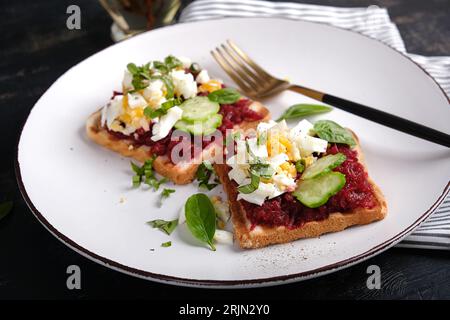Healthy toast with pate beetroot, boiled eggs, basil and cucumbers. Delicious breakfast or snack. Stock Photo