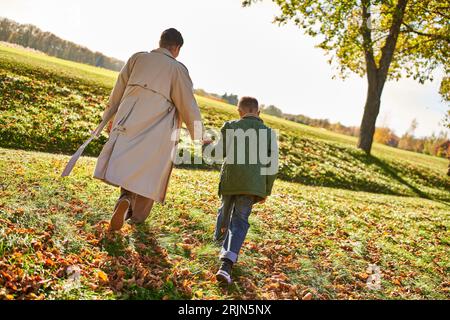 golden hour, mother and son walking in park, hold hands, autumn leaves, fall, african american Stock Photo