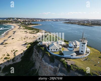 Aerial view of Nobbys Lighthouse and Stockton Beach with vast ocean and towering cliffs in the background Stock Photo