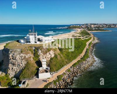 Aerial view of Nobbys Lighthouse and Stockton Beach with vast ocean and towering cliffs in the background Stock Photo