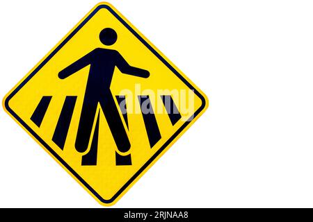 A yellow street sign depicting a silhouette of a person walking across a crosswalk with copy space Stock Photo