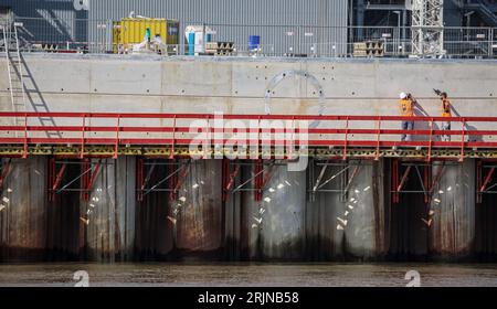 23 August 2023, Lower Saxony, Stade: Workers stand on the construction site of the LNG terminal on the Elbe River in Stade. The liquefied gases jetty is scheduled for completion in winter 2023/24. Photo: Focke Strangmann/dpa Stock Photo