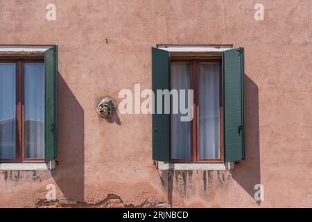 Glass window and green shutter on red wall backgrounds Stock Photo