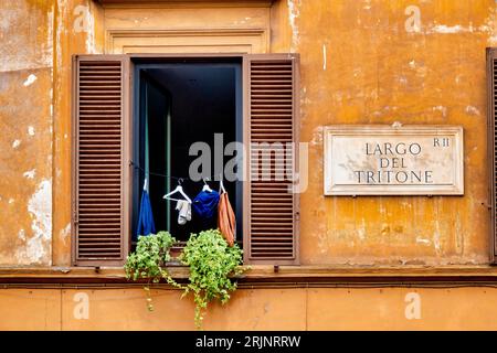 Clothes left to dry in a window on Largo del Tritone, Rome, Italy Stock Photo