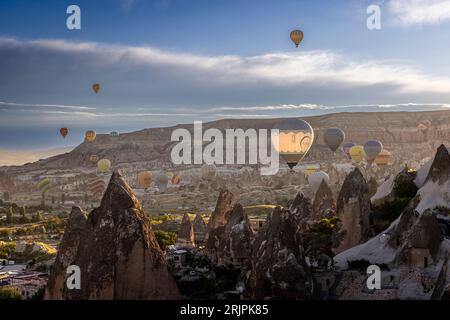 GOREME TURKEY - June 27, 2022: hot air balloons fly  over the city of goreme at sunrise Stock Photo