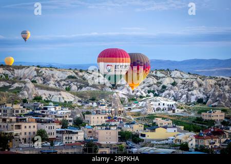 GOREME TURKEY - June 27, 2022: hot air balloons fly low over the city of goreme at sunrise Stock Photo
