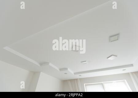 Stretched white matte ceiling in the room close-up Stock Photo