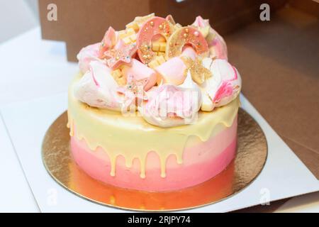 Birthday gradient pink cake with meringue clouds, chocolate donuts, sprinkles, stars and melted white chocolate on the top for a little princess Stock Photo