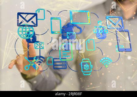 A close-up of a man in a gray button up shirt interacting with a hologram featuring different icons Stock Photo