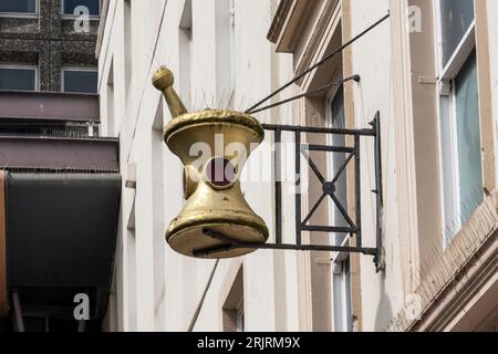 Traditional mortar and pestle sign on a building, indicating a dispensing pharmacy in Dundee, Scotland. Stock Photo