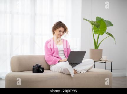 Beautiful Young Photographer Woman Using Laptop At Home, Retouching Photos Stock Photo