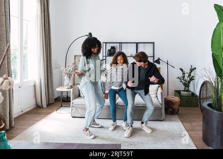 Happy family havin fun dancing together in the living room Stock Photo