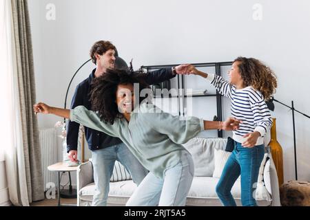 Happy family havin fun dancing together in the living room Stock Photo