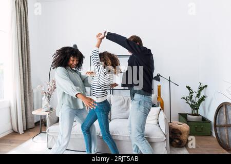 Happy family havin fun dancing together in the living room Stock Photo