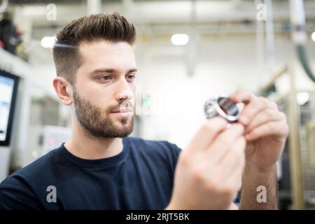 Man examining workpiece in a factory Stock Photo