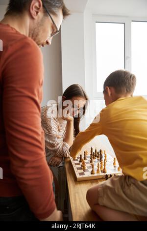 Woman playing chess with son at home Stock Photo